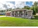 Beautiful single-story home showcasing a well-manicured lawn and a welcoming front porch with decorative columns at 5026 Sw 128Th St, Ocala, FL 34473