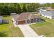 Inviting single-Gathering home featuring a lush lawn, concrete driveway, and charming front porch at 5026 Sw 128Th St, Ocala, FL 34473