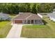 Inviting single-Gathering home featuring a lush lawn, concrete driveway, and charming front porch at 5026 Sw 128Th St, Ocala, FL 34473