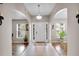 Bright foyer featuring tile and hardwood floors, arched doorways, and a view of the naturally lit living spaces at 5026 Sw 128Th St, Ocala, FL 34473