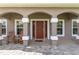 Inviting front porch with brick pavers, decorative columns, and comfortable seating creating a welcoming entrance at 5026 Sw 128Th St, Ocala, FL 34473