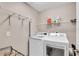 Modern laundry room featuring front-load washer and dryer and wire shelving at 5026 Sw 128Th St, Ocala, FL 34473