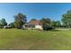 Spacious backyard with a seating area, manicured lawn, and mature trees at 5363 Nw 153Rd Ct, Morriston, FL 32668