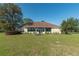 Expansive backyard features lush green lawn, mature trees, and outdoor seating area at 5363 Nw 153Rd Ct, Morriston, FL 32668