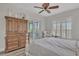 Bright bedroom boasts a ceiling fan, French doors, a dresser, a comfortable chair and wood floors at 5363 Nw 153Rd Ct, Morriston, FL 32668