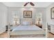 Bright bedroom with wood floors boasts plantation shutters, a ceiling fan and white furniture at 5363 Nw 153Rd Ct, Morriston, FL 32668