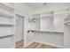 Spacious closet featuring hardwood floors, white shelving, drawers, and hanging rods at 5363 Nw 153Rd Ct, Morriston, FL 32668