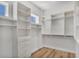 Spacious closet featuring wood floors, white shelving, drawers, hanging rods, and a window at 5363 Nw 153Rd Ct, Morriston, FL 32668