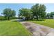 Long driveway leading to a home with a garage, lawn and trees at 5363 Nw 153Rd Ct, Morriston, FL 32668