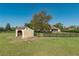 Exterior view of the home featuring a fenced yard and outbuilding at 5363 Nw 153Rd Ct, Morriston, FL 32668