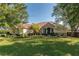 Charming single-story home featuring a stone facade, manicured lawn, and mature trees at 5363 Nw 153Rd Ct, Morriston, FL 32668