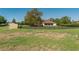 Exterior view showcasing the fenced yard, mature trees, and outbuilding at 5363 Nw 153Rd Ct, Morriston, FL 32668