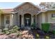Elegant front entrance featuring a stone archway and landscaping, creating a welcoming curb appeal at 5363 Nw 153Rd Ct, Morriston, FL 32668