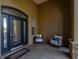 Inviting front porch with seating area, tiled flooring, and a glass front door at 5363 Nw 153Rd Ct, Morriston, FL 32668