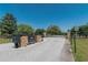 Community entrance gate with brick pillars, black metal fencing, and well-maintained landscaping at 5363 Nw 153Rd Ct, Morriston, FL 32668