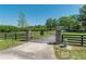 Gated entrance to the property with stone pillars and well-manicured lawn at 5363 Nw 153Rd Ct, Morriston, FL 32668