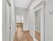 Hallway featuring hardwood floors, white trim, a door leading to the bathroom, and a closet at 5363 Nw 153Rd Ct, Morriston, FL 32668