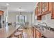 Charming kitchen featuring wood cabinets, stainless appliances, an island with bar stool seating and a table near the window at 5363 Nw 153Rd Ct, Morriston, FL 32668