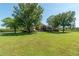 A house with a well-manicured front lawn and mature trees at 5363 Nw 153Rd Ct, Morriston, FL 32668