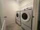 Bright laundry room featuring a modern washer and dryer with overhead wire shelving at 593 Marion Oaks Trl, Ocala, FL 34473