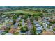 An aerial view showcases a charming neighborhood with lush greenery and a tranquil pond at 710 Antonia Ln, The Villages, FL 32159