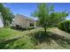 Spacious backyard with a green lawn, well-trimmed hedges, and the home's siding in view at 710 Antonia Ln, The Villages, FL 32159