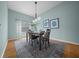 Cozy dining room with a modern light fixture, accent wall art, and hard wood flooring at 710 Antonia Ln, The Villages, FL 32159