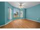 Cozy room featuring hard wood flooring, neutral blue walls, and large bay windows at 710 Antonia Ln, The Villages, FL 32159