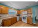 Well-lit kitchen featuring granite countertops, wooden cabinets and modern appliances at 710 Antonia Ln, The Villages, FL 32159