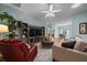 Open living space with a media center, a ceiling fan, and a view into the dining area at 710 Antonia Ln, The Villages, FL 32159