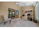 Well-lit sunroom featuring a ceiling fan, large sliding glass doors, and a functional desk area at 710 Antonia Ln, The Villages, FL 32159