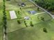 Expansive aerial view of a sprawling estate showcasing lush pastures, multiple homes, and equestrian facilities at 7161 Ne 22Nd Court Rd, Ocala, FL 34479
