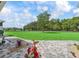 Expansive green backyard offering a view of towering trees, and a stone patio with landscaping at 7161 Ne 22Nd Court Rd, Ocala, FL 34479