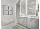 Bright bathroom featuring double vanity with illuminated mirrors, stylish decor, and marble flooring at 7161 Ne 22Nd Court Rd, Ocala, FL 34479