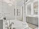 Luxurious bathroom featuring a standalone tub, dual vanities with illuminated mirrors, and elegant chandeliers at 7161 Ne 22Nd Court Rd, Ocala, FL 34479