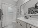 Well-lit bathroom featuring white tile, a vanity with modern fixtures, and a shower with a decorative curtain at 7161 Ne 22Nd Court Rd, Ocala, FL 34479