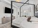Elegant main bedroom featuring a four-poster bed, neutral decor, and a view to the adjacent sitting room at 7161 Ne 22Nd Court Rd, Ocala, FL 34479