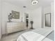 Bright bedroom featuring a light grey dresser with unique décor, wood floors, and a view into another room at 7161 Ne 22Nd Court Rd, Ocala, FL 34479