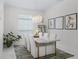 Bright dining room with white furniture, statement lighting, horse artwork, and natural light streaming in from the window at 7161 Ne 22Nd Court Rd, Ocala, FL 34479