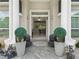 Inviting entryway with decorative planters and gray tiled flooring leading to the open front door at 7161 Ne 22Nd Court Rd, Ocala, FL 34479