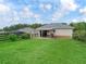 Rear view of the outbuilding with covered patio and spacious lawn at 7161 Ne 22Nd Court Rd, Ocala, FL 34479