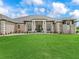 A lush green lawn complements the grand exterior of this single-story home with a covered front entryway at 7161 Ne 22Nd Court Rd, Ocala, FL 34479
