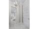 Bright hallway with marble floors, a decorative column, and a view of a luxurious marble tiled shower at 7161 Ne 22Nd Court Rd, Ocala, FL 34479