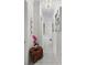 Bright hallway with elegant white marble floors, decorative artwork, and a unique wooden accent table with flowers at 7161 Ne 22Nd Court Rd, Ocala, FL 34479