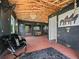 A well-appointed horse barn features black walls, red brick floors, wood ceilings, stalls, and comfortable seating at 7161 Ne 22Nd Court Rd, Ocala, FL 34479