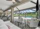 Spacious screened patio with comfortable seating and a view of the pool and lush backyard at 7161 Ne 22Nd Court Rd, Ocala, FL 34479