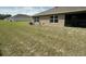 Spacious backyard featuring a well-maintained lawn, windows, and a sliding glass door at 7198 Sw 136Th Street Rd, Ocala, FL 34473