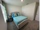 Bedroom featuring a neutral gray upholstered bed frame with blue bedding and a side table at 7198 Sw 136Th Street Rd, Ocala, FL 34473