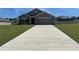 Charming single-story home with a well-manicured lawn and a long driveway leading to a two-car garage at 7198 Sw 136Th Street Rd, Ocala, FL 34473