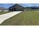 Charming single-story home featuring a well-manicured lawn and a long driveway leading to an attached garage at 7198 Sw 136Th Street Rd, Ocala, FL 34473